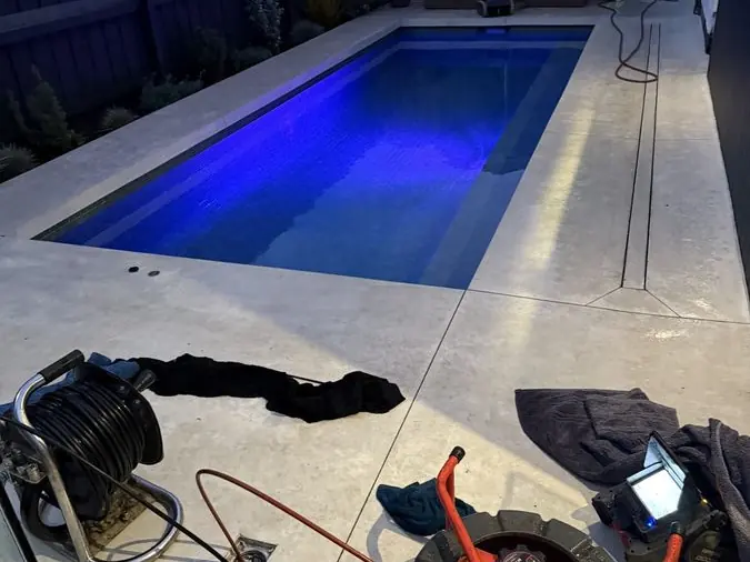 Drain cleaning equipment beside a pool area, Carrum Downs